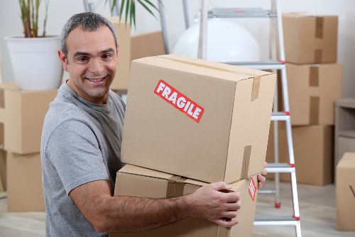 Professional piano removals team handling an upright piano in Poplar
