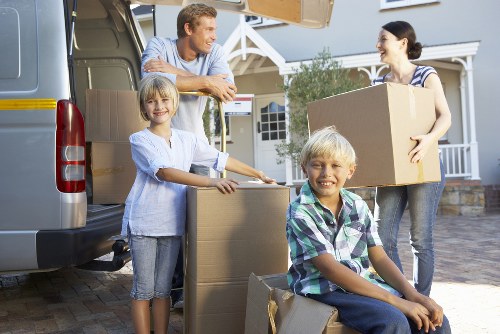 Professional movers loading boxes into a removal van in Poplar